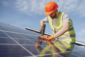 Photo d'un installatreur en train de poser des panneaux photovoltaïques